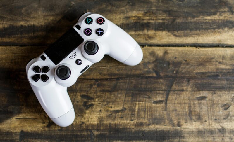 White game controller resting on a rustic wooden surface, top view.