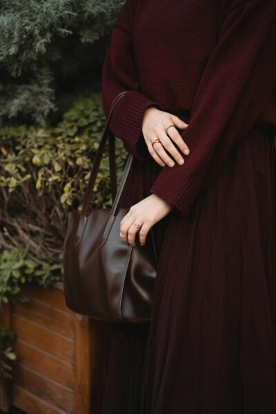 Stylish maroon outfit accessorized with a matching leather handbag, perfect for fall fashion.