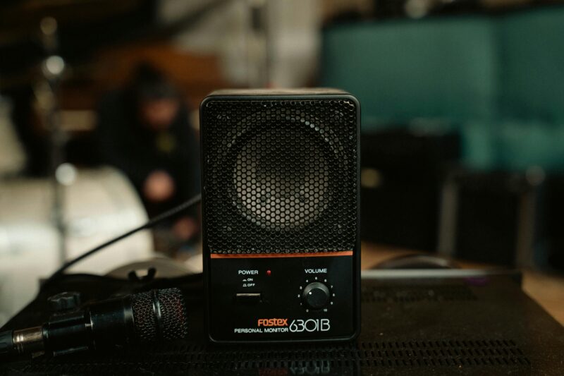 Detailed view of a Fostex 6301B personal monitor with a microphone in a cozy indoor setting.