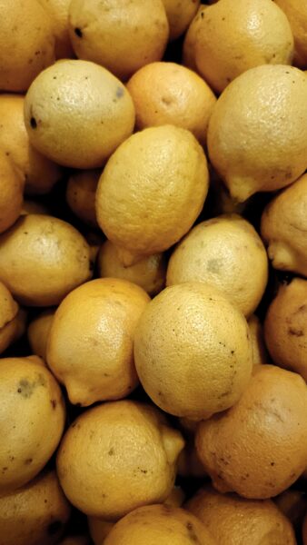 A close-up view of a large pile of fresh lemons, great for food and produce themes.