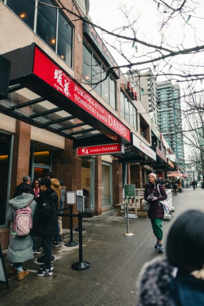 People walking on a winter day near a ramen restaurant in Vancouver, BC.