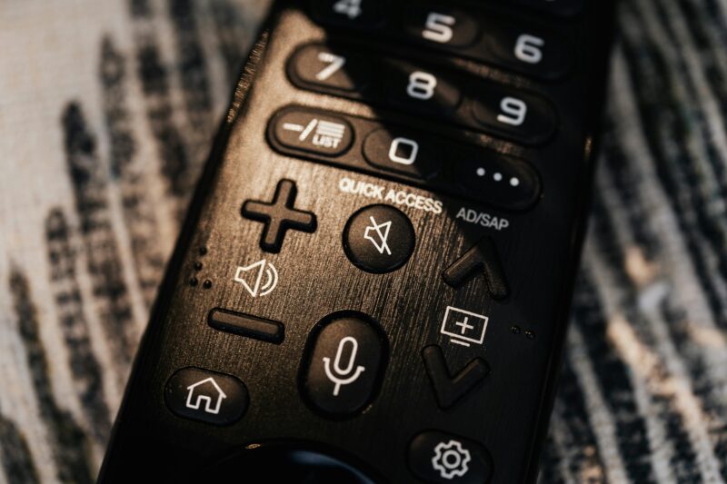 Detailed close-up of a modern black remote control emphasizing buttons and functions.