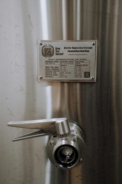 Vertical shot of a stainless steel valve with label, ideal for industrial applications.