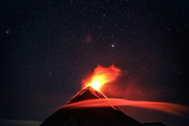 A dramatic volcano eruption in Guatemala beneath a star-filled night sky, showcasing nature's power.