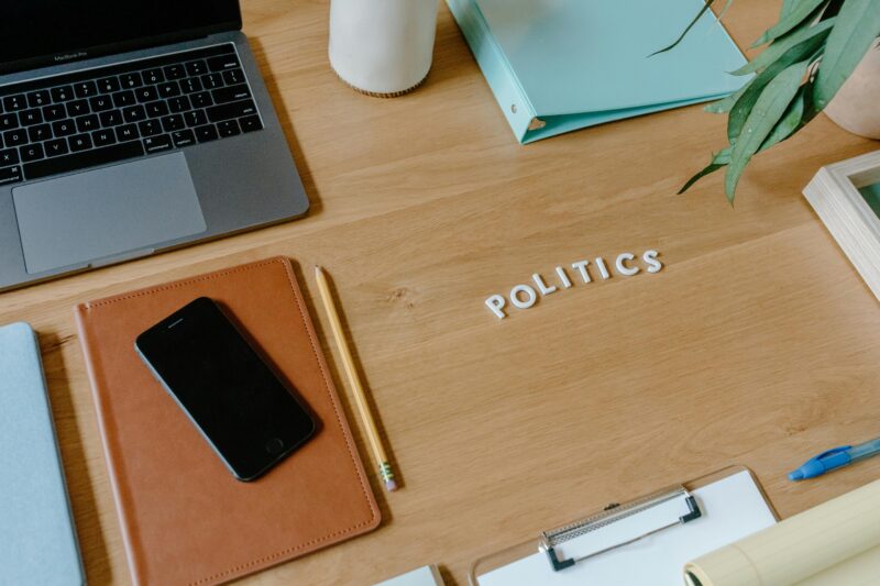 Neat office desk setup with laptop, smartphone, and political theme.