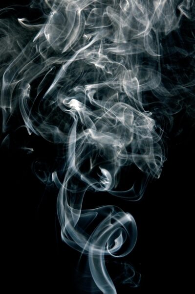 Intricate patterns of swirling smoke on a black background, creating an abstract visual.