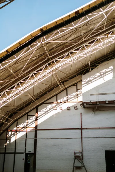 Dramatic view of a hangar ceiling showcasing steel truss construction and natural light.