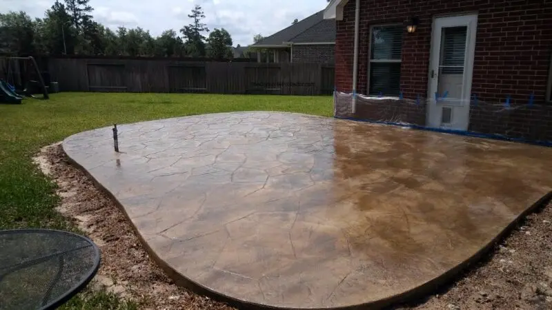 A circular concrete patio with a stamped texture.