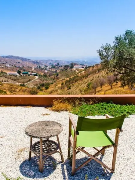 A charming outdoor area with a table and chairs set on a pea gravel patio.