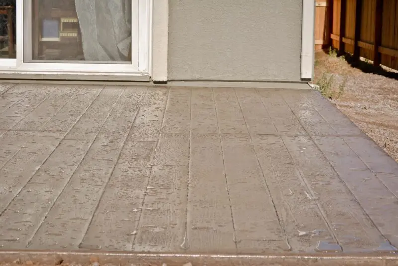 Finished product of backyard stamped concrete patio by our landscaping company.