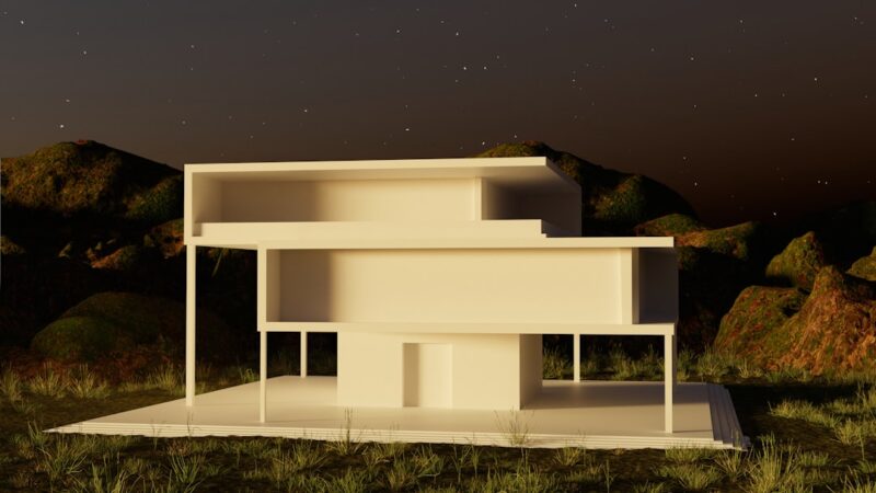 A white building sitting on top of a lush green field.