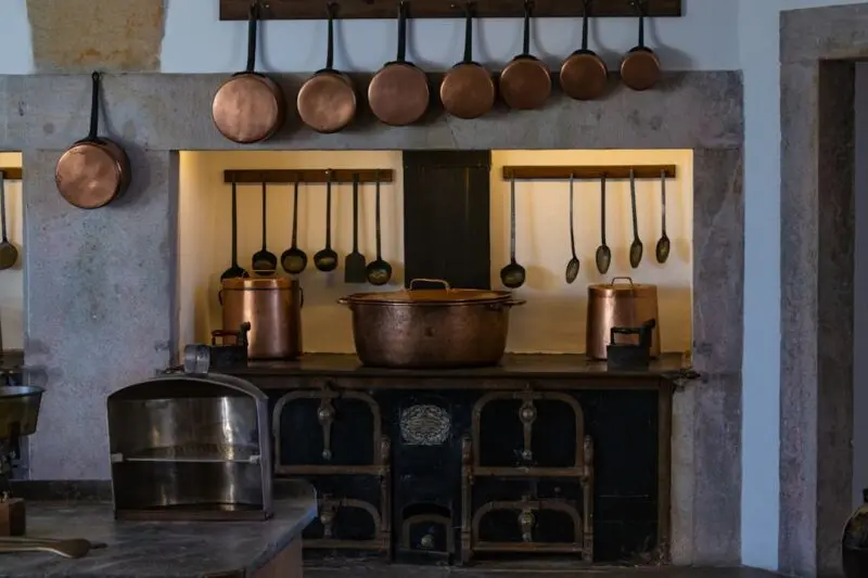 A kitchen with pots and pans hanging on the wall.