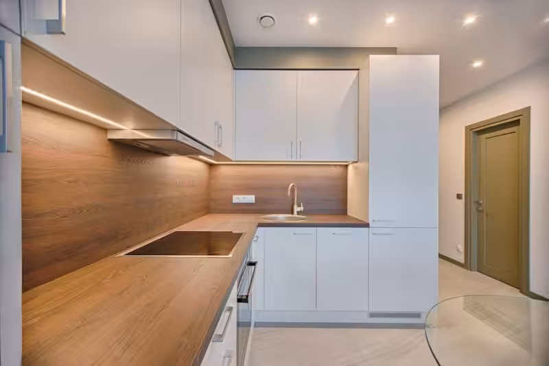 Modern kitchen interior with cabinets, counters, and natural light