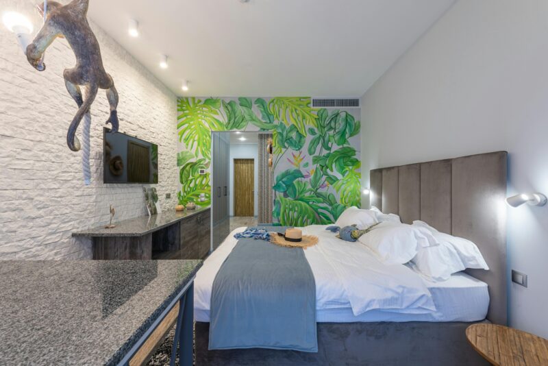A cozy resort suite featuring tropical wall decor and modern furnishings.