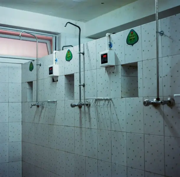 White and gray 3-person shower stall.