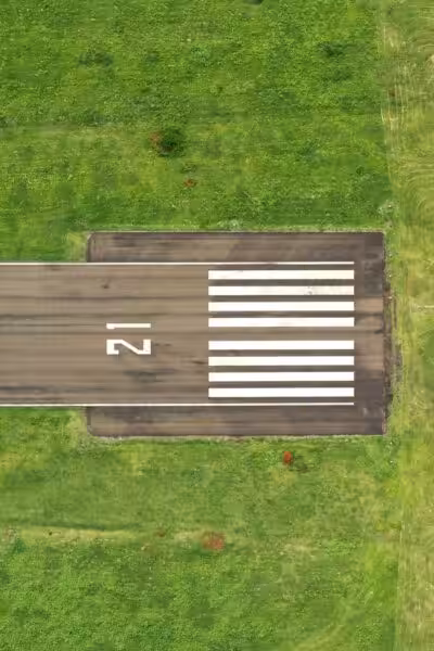 Grey pavement on green grass field