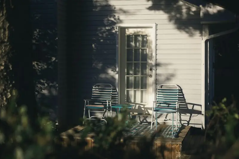 Black and white wooden armchair beside white wooden house