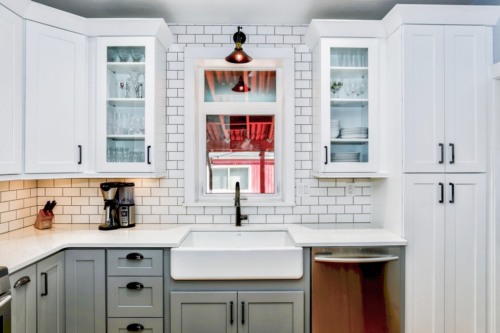 Small kitchen with white Carrara marble mosaic backsplash brightening the space.