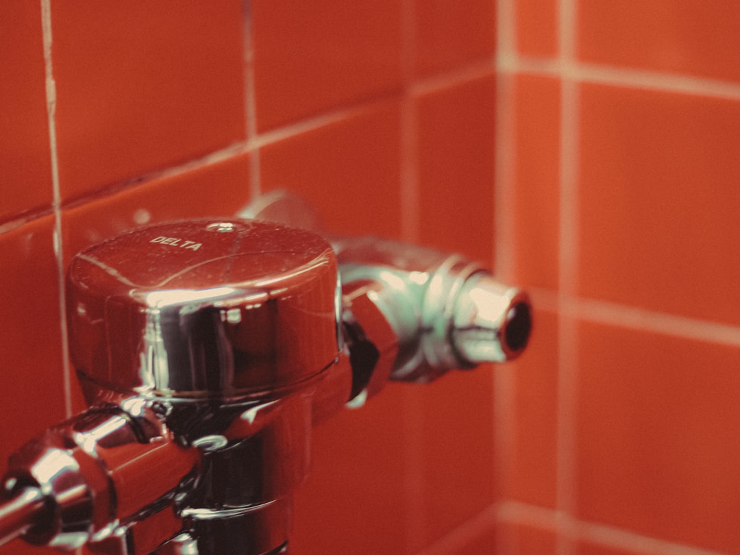 A red tiled bathroom with a chrome faucet