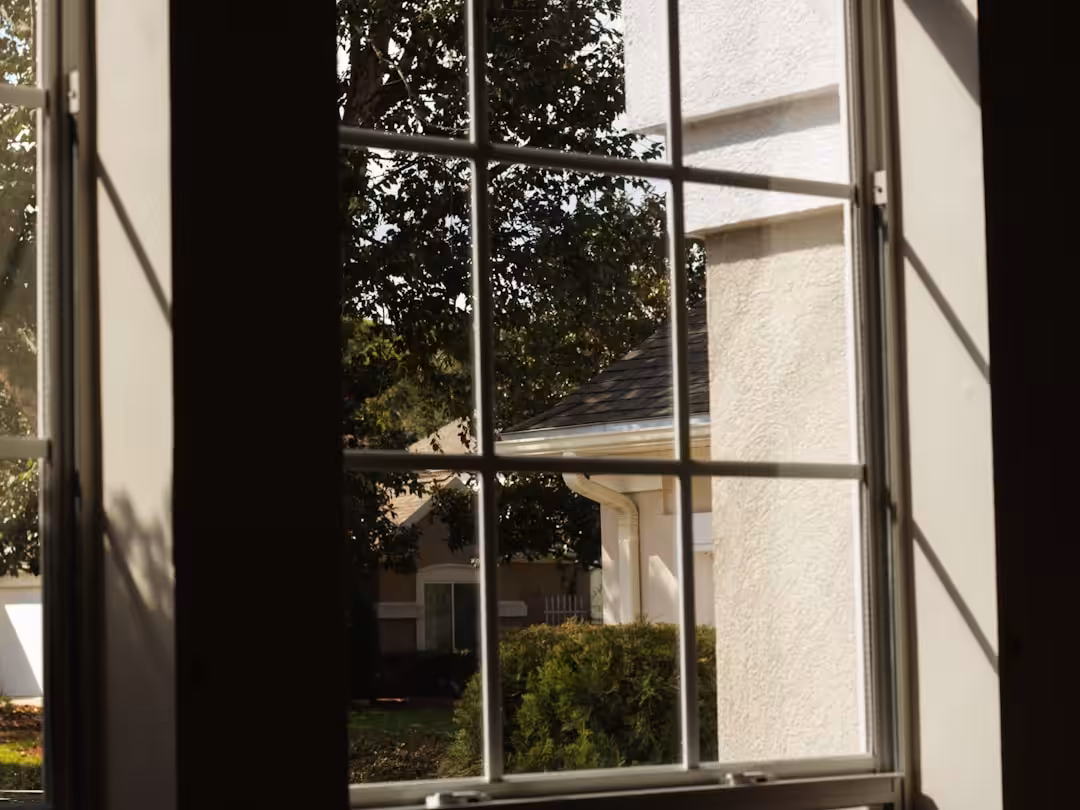 a window with a view of a house and trees