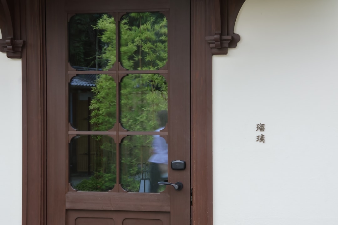 A man is reflected in the glass of a door