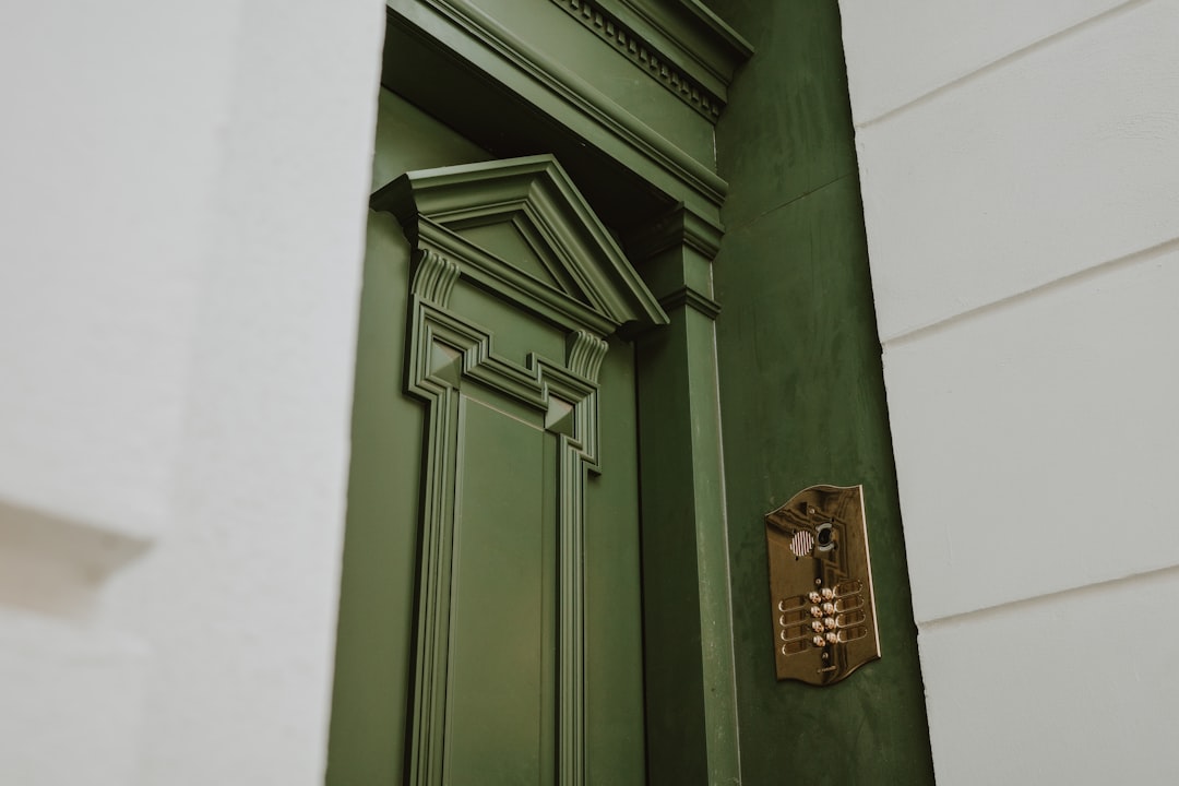 A green door with a detailed, ornate frame.