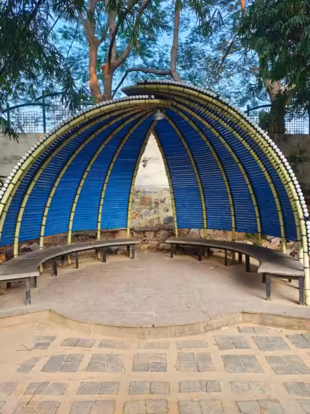 Bamboo canopy outdoor seating with benches in a serene natural setting.