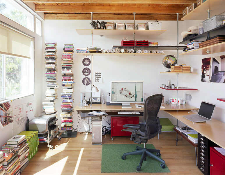 An organized workspace with floating shelves and a sleek desk setup designed for productivity.