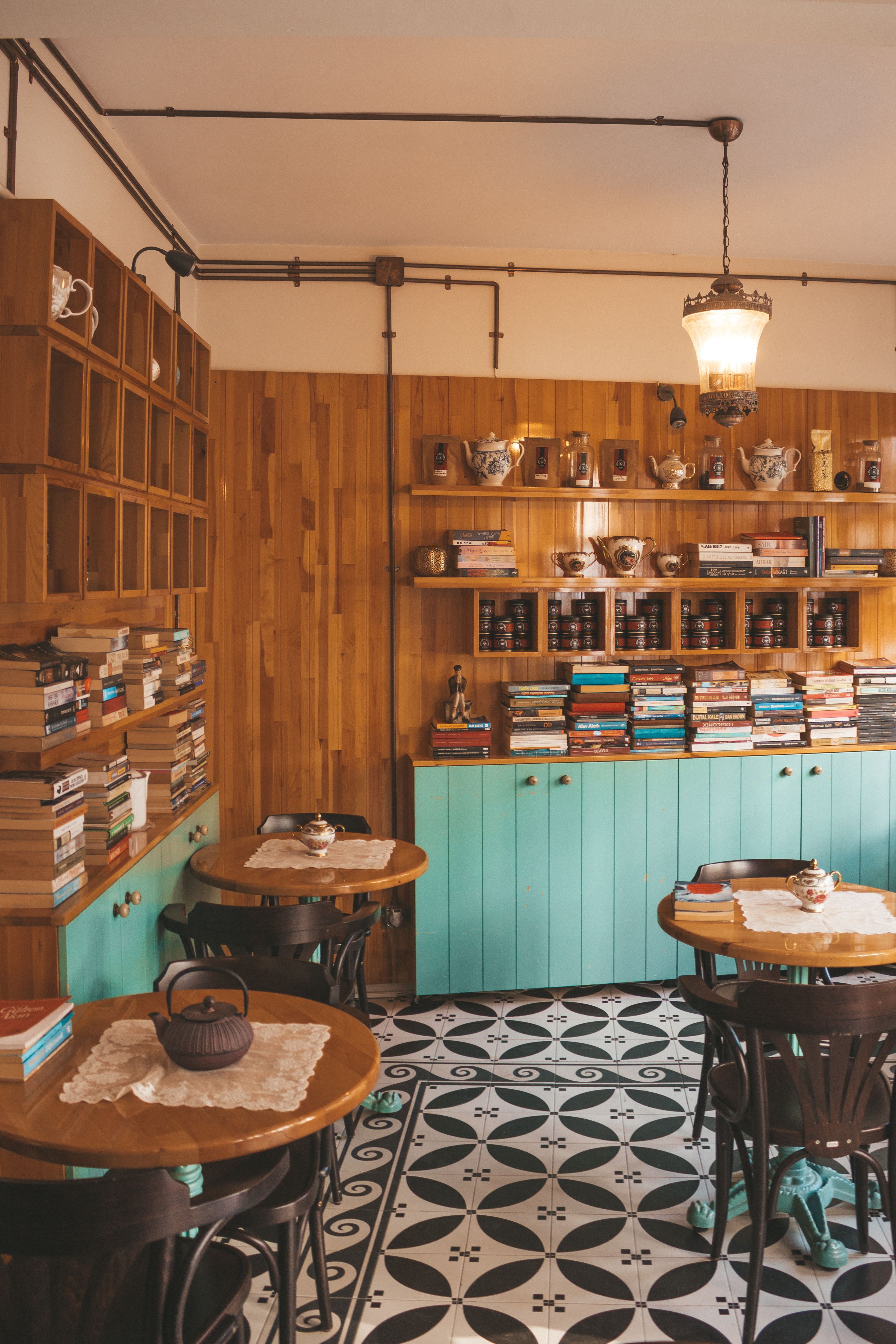 Warm and inviting coffee shop with books, wooden walls, and vintage decor.