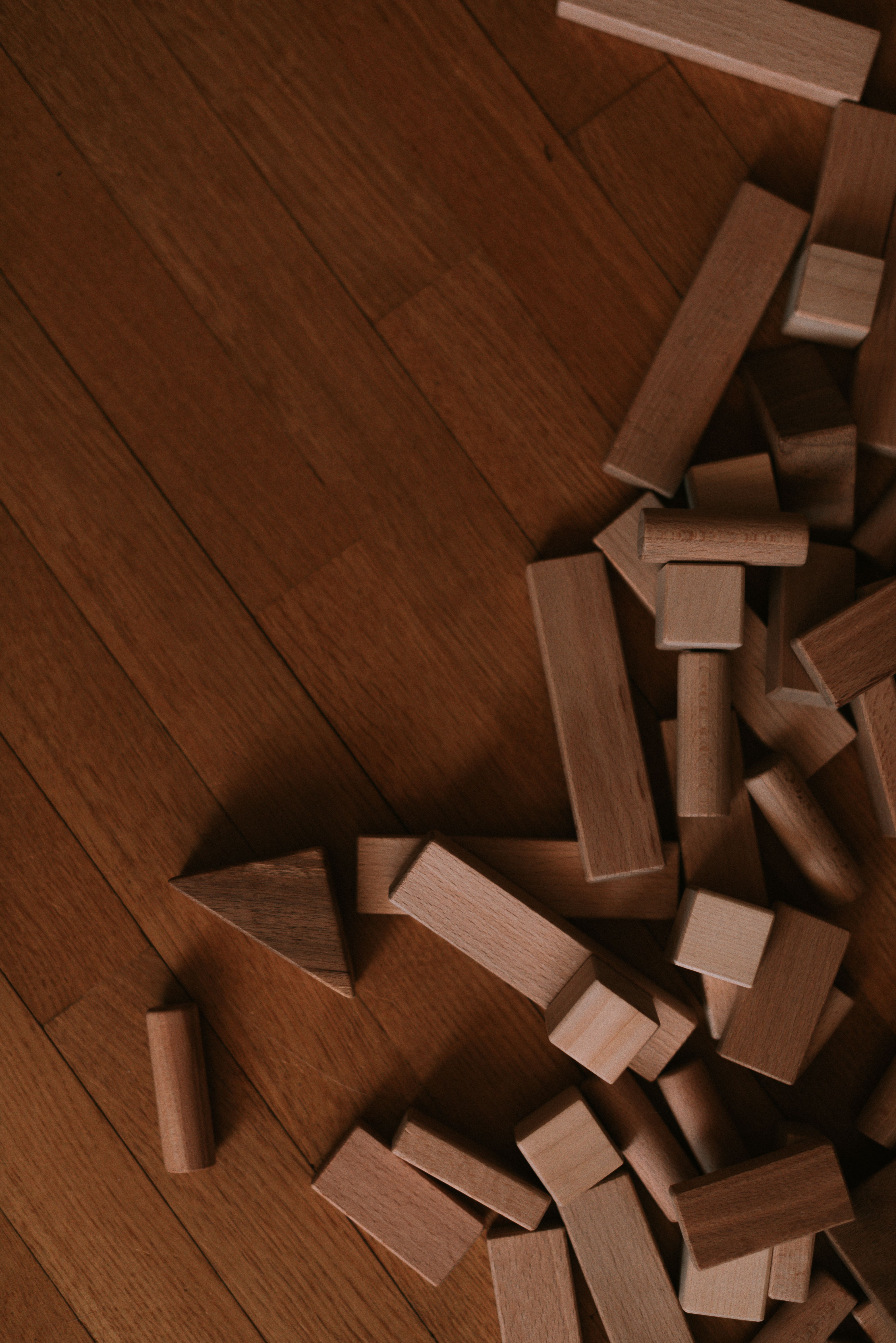 Scattered wooden blocks on a hardwood floor, showcasing playful creativity.