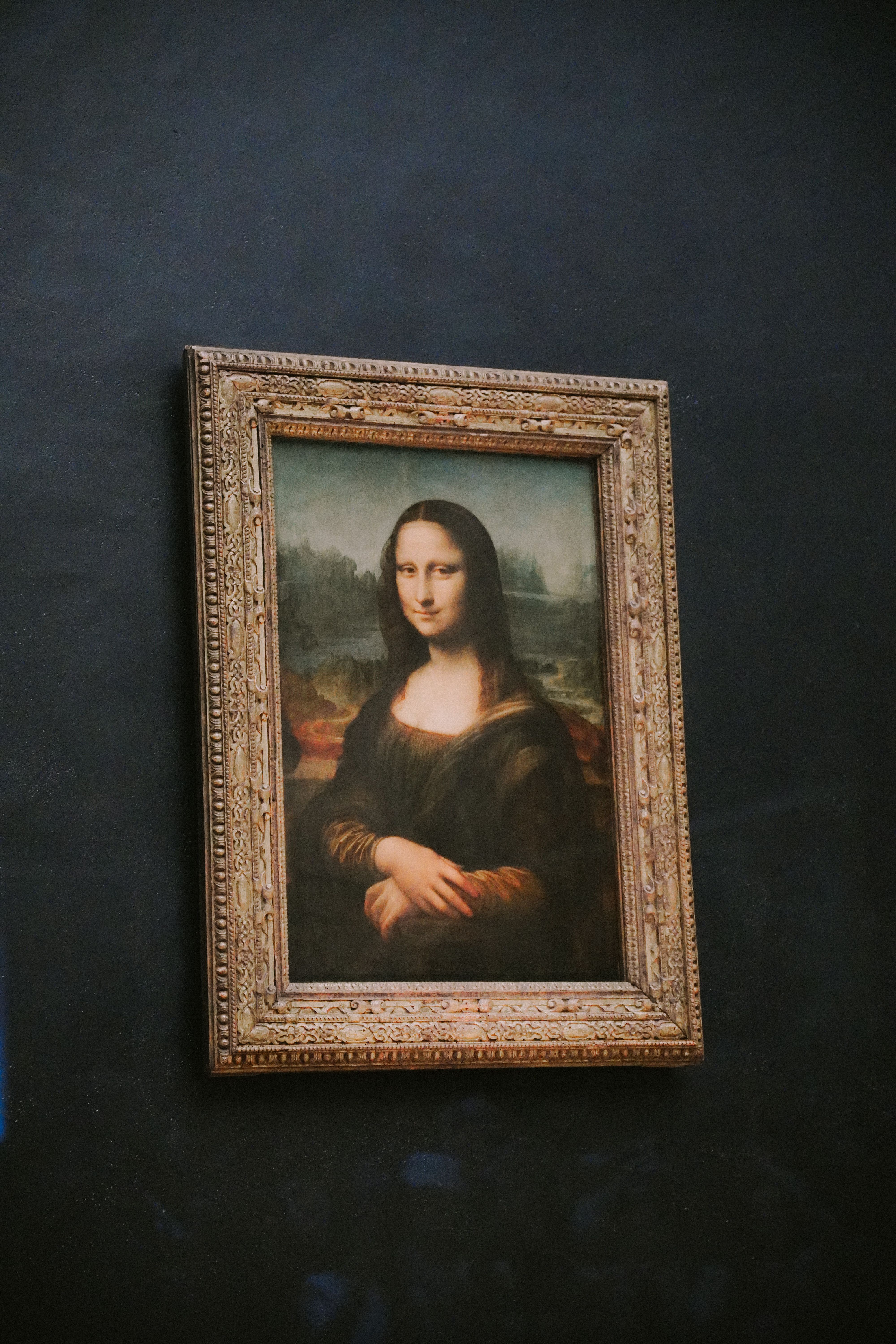 Iconic painting of Mona Lisa displayed in a Paris museum setting.
