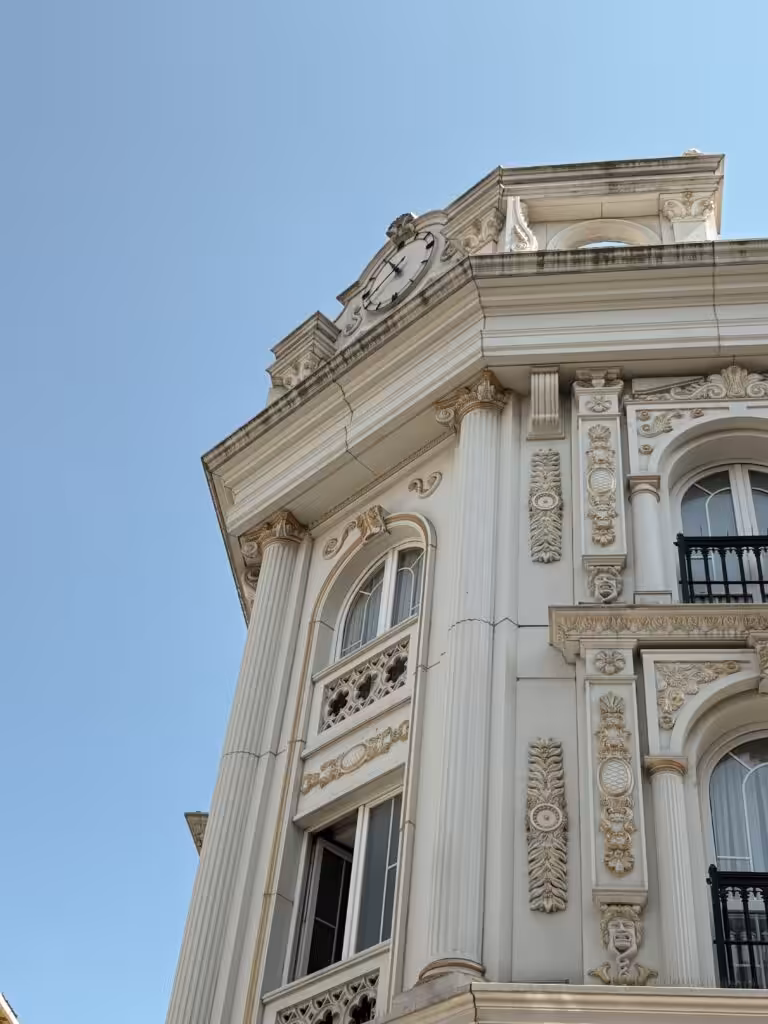 Close-up of an ornate Renaissance Revival building facade under a clear blue sky.