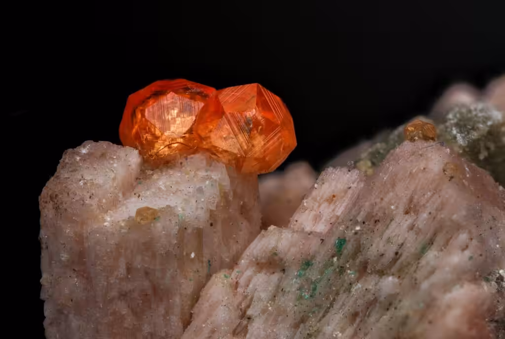 Detailed close-up of vibrant red crystals on a mineral rock background.