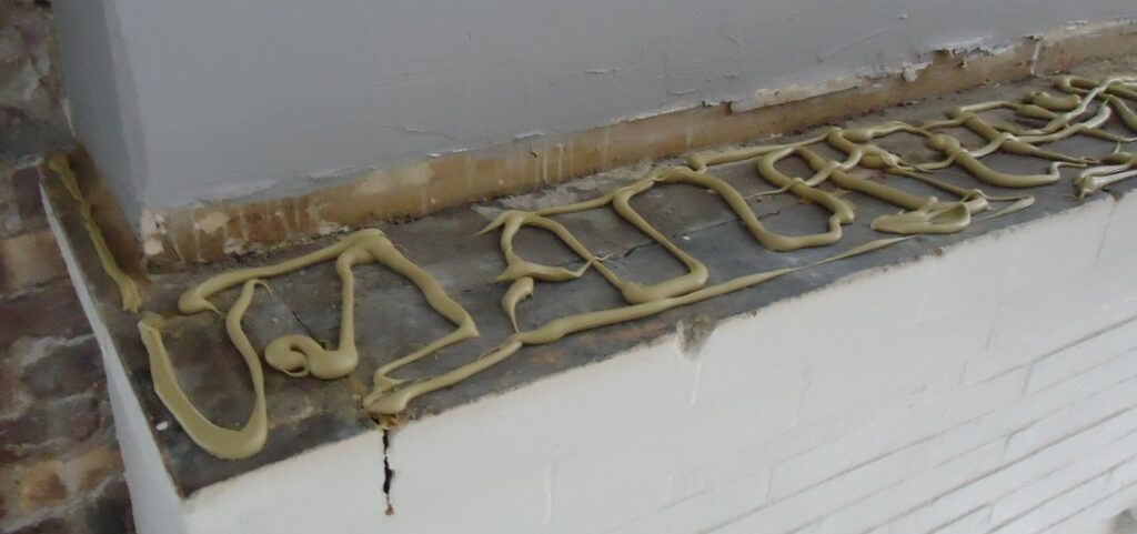 Kitchen renovation 9a construction adhesive on bricks before placing mantle board on top.