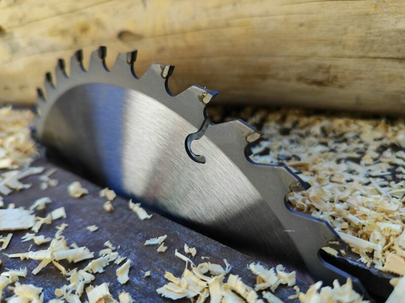 a close up of a metal blade on a piece of wood