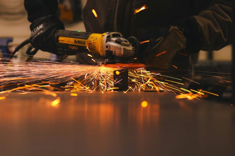 A man working with a grinder on a piece of metal