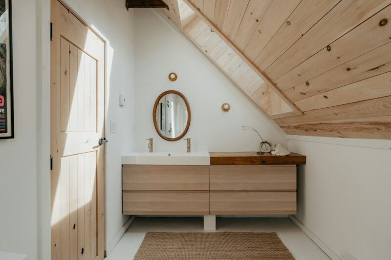 Compact bathroom with floating natural wood shelves arranged neatly above the toilet providing practical storage.