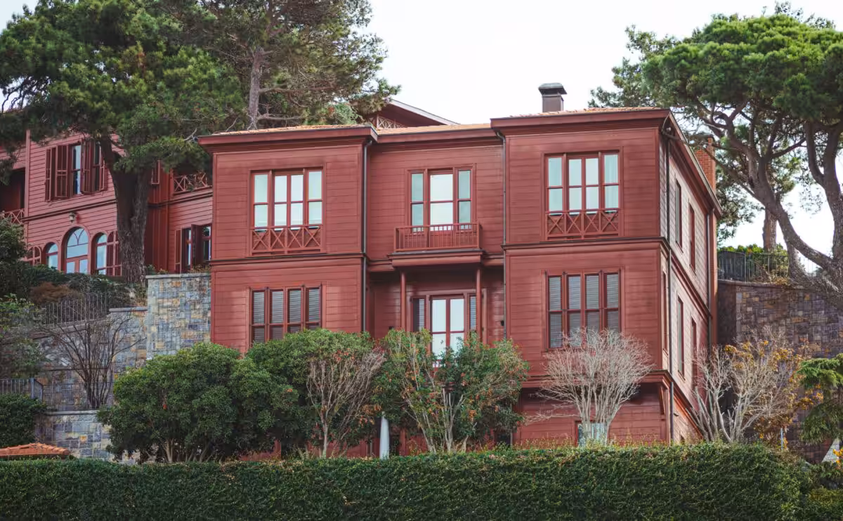 A picturesque red house surrounded by greenery in an urban setting in Istanbul, Turkey.