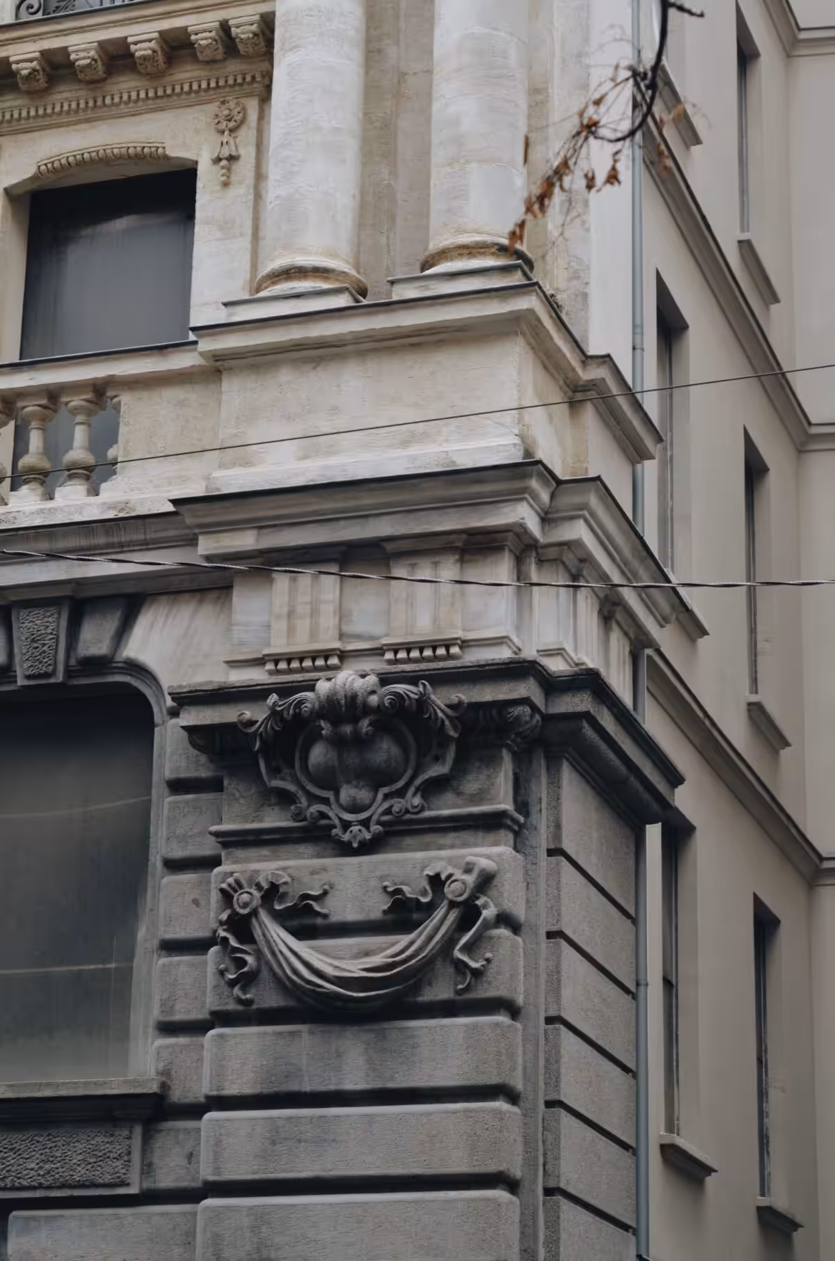 Detailed view of an ornate neoclassical building corner with architectural carvings.