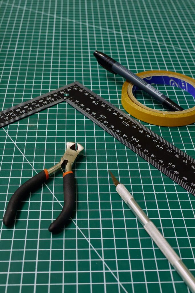 Assorted crafting tools on a green grid cutting mat, ready for use.